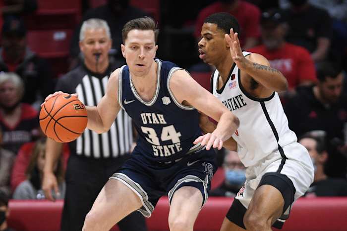 Feb 15, 2022; San Diego, California, USA; Utah State Aggies forward Justin Bean (34) dribbles the ball while defended by San Diego State Aztecs forward Keshad Johnson (0) during the first half at Viejas Arena.